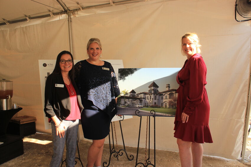 Dana Sargent, Nicole Briggs and Katherine Bunnell stand next to the rendering of The Blake at St. Johns during a mix and mingle social event on site.