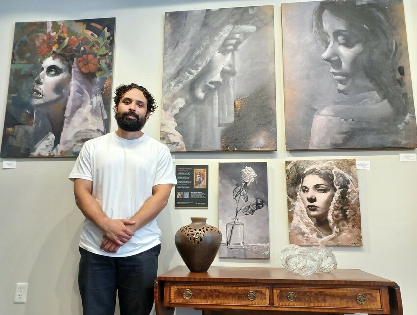 Artist Alfredo Gonzalez stands amid several of his paintings exhibited at The Grand Bohemian Gallery in St. Augustine.