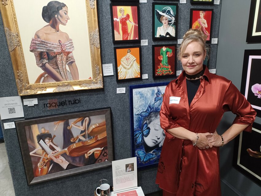 Raquel Rub&iacute; stands before an exhibit of her work at Art Box 137 in St. Augustine. Most of the paintings depict characters she has portrayed, though the large one at left, &ldquo;La Divina,&rdquo; is a picture of opera star Maria Callas.