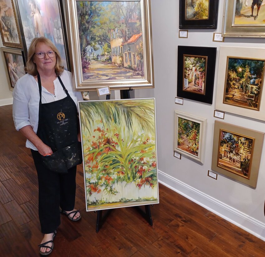 Martha Ferguson stands next to an exhibit of her new paintings at The Grand Bohemian Galley in St. Augustine.