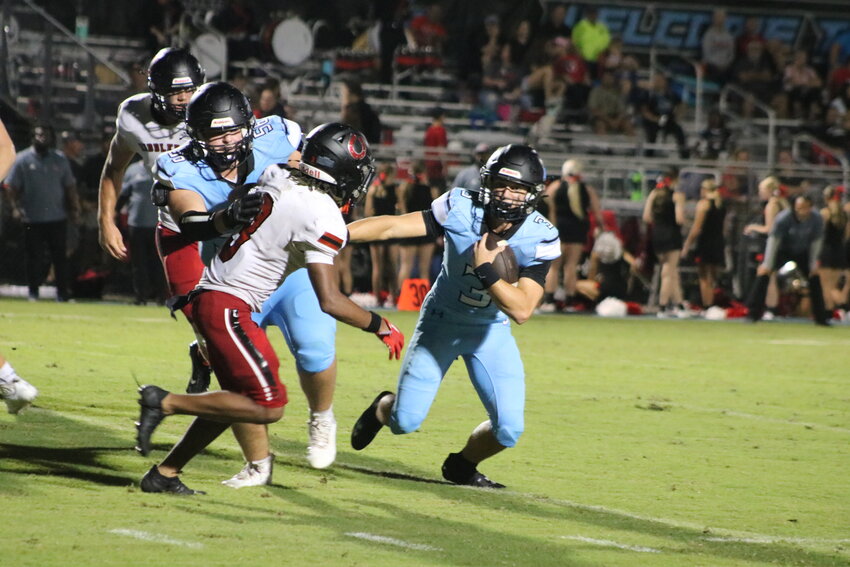 Ben Burk looks for running room on a quarterback keeper. The senior finished with a career-high five passing touchdowns on the night.