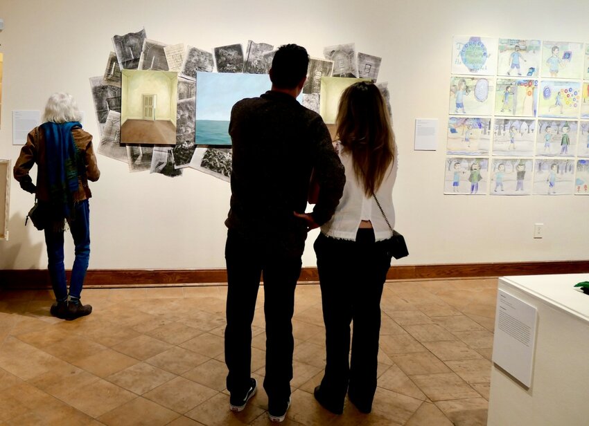 Guests examine the work of one student.