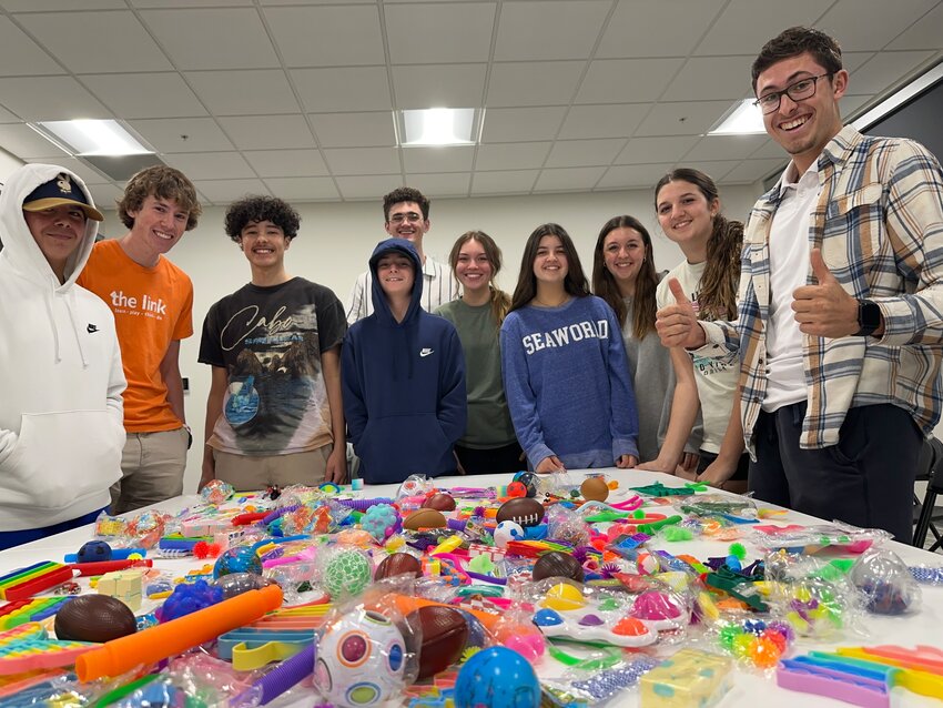 Members of the link&rsquo;s teen club are shown with some of the sensory toys they collected for children with autism.