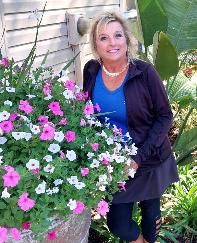 Kathy Esfahani stands next to a huge planter bursting with flowers at her garden center, located at 196 N. Roscoe Blvd., in Ponte Vedra.