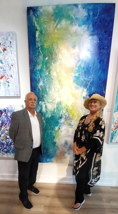 Artist Al Razza and gallery owner Dede Sweet in front of Razza&rsquo;s 96-by-48-inch work, &ldquo;Turbulence.&rdquo;