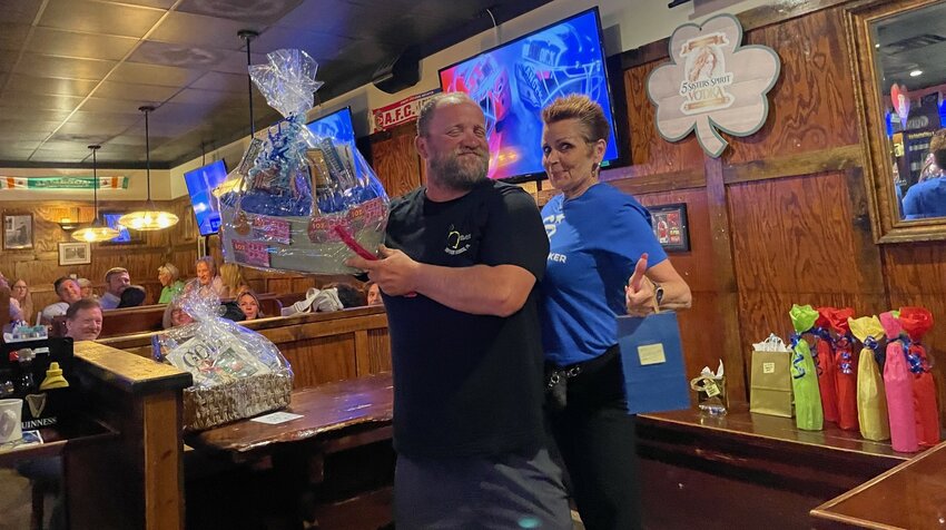 Bingo attendee Patrick Shadduck, who won a lottery scratch off and Visa gift card basket, is seen with Coldwell Banker Vanguard Realty Broker Manager Michele DeLiberto.