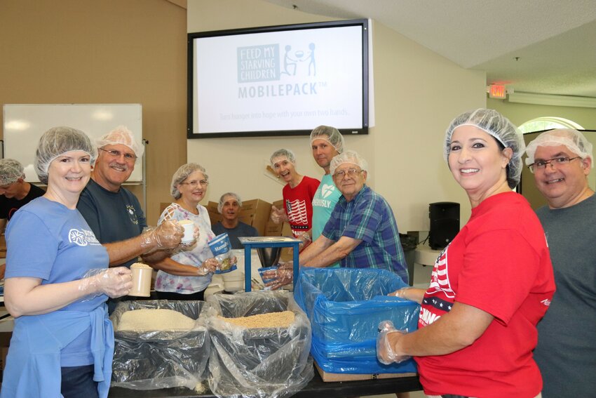 Volunteers pack food that will help feed hundreds of starving children during a past MobilePack event.