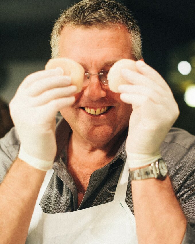 Jeff Spear holds scallops up in front of his eyes.