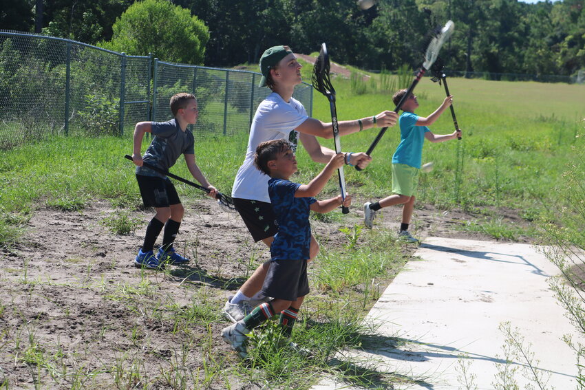 A counselor works with a camper at the Nease lacrosse camp.