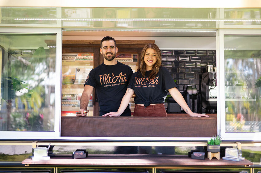 Carlos and Hannah Lopez await customers at the window of their Fire &amp; Ash truck.