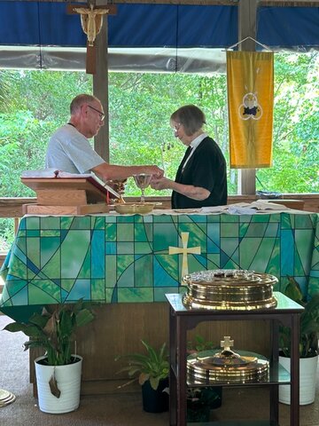 Pastor Karen Biggerstaff is assisted by Richard Marzocchi during a service.