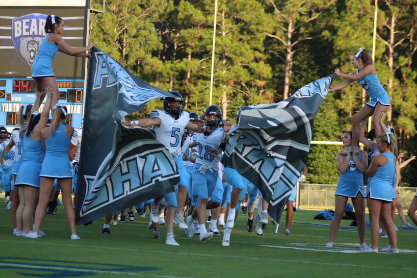 The Ponte Vedra Sharks run through a banner to take the field.