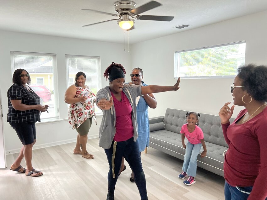 Antwanette and her family express their excitement in seeing her new living room.