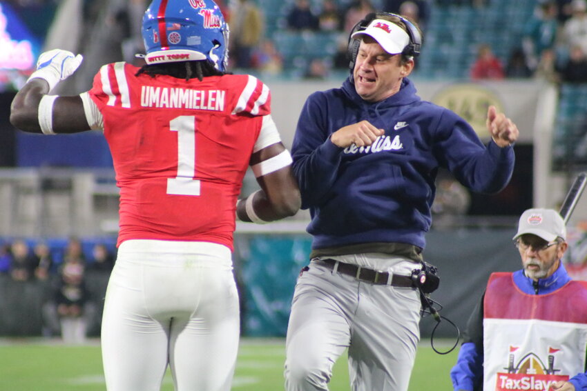 Ole Miss head coach Lane Kiffin celebrates with Princely Umanmielen after a defensive touchdown.