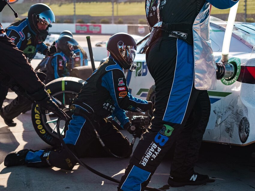 Chris Shuman drops to his knees and removes the single lug nut and tire, then replaces them with a new tire and lug nut - all in about four seconds.