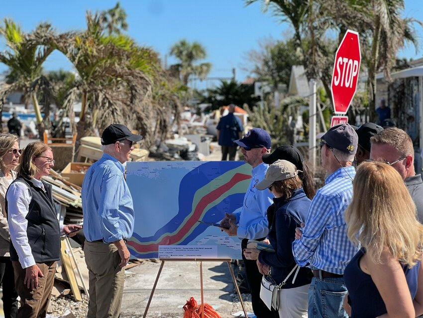 President Biden (left of poster), arrives in St. Petersburg to survey Hurricane Milton damage.