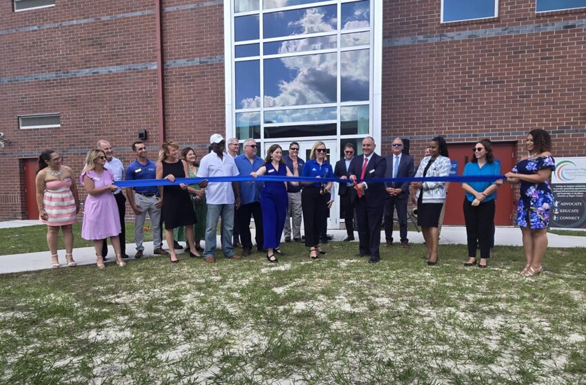 School Board Chair Will Furry (center, red tie) cuts the ribbon on Matanzas High School's new expansion.