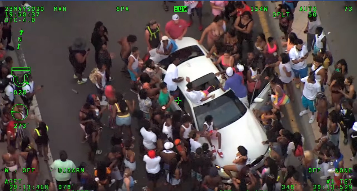 The view from Air One as an unidentified man throws money towards a crowd of people during yesterday's events