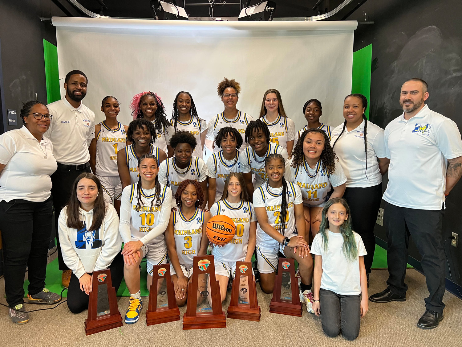 Coach Brandon Stewart (second from left) led the Mainland High School girls' basketball team to a state championship this past season.