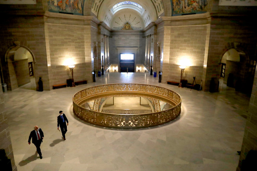 People wear protective masks as they walk in the rotunda at the state Capitol Monday, April 27, 2020, in Jefferson City, Mo.&nbsp;