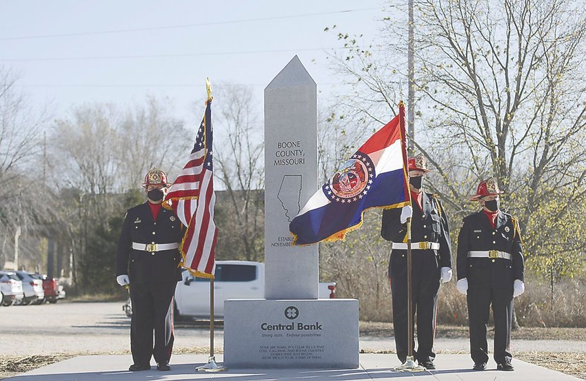 Nathan Luebbering, Gary Berendzen and Steve Cearlock with the Cole County Honor Guard flank a statue honoring Boone, Cole and Callaway counties. . s.