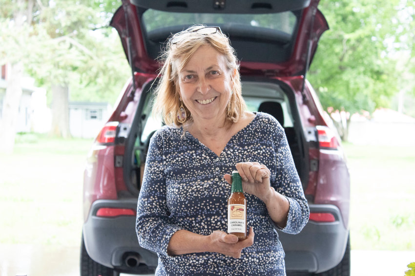 Carol Rodriguez, 71, stands with just one of the multiple reductions, sauces, and marinades she sells at the Sedalia Area Farmers&rsquo; Market. Carolina&rsquo;s Caramel can be used to make lattes, cheesecakes, or other desserts.
