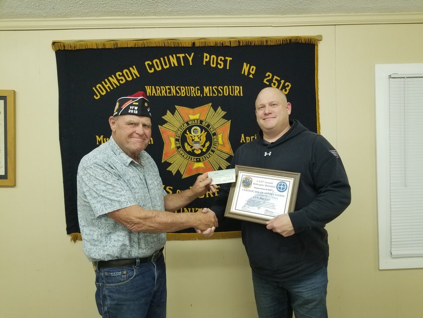 William A. Carleton Veterans of Foreign Wars Post Commander Howard Good, left, presents Staff Sgt. Travis Mobley with a $990 check from Warrensburg's VFW Post 2513 and American Legion Post 131 and Knob Noster VFW Post 4195 for soldiers&rsquo; meals at their unit Christmas party.