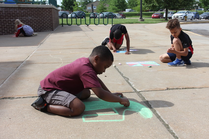 Summer Day Camp Explorers, third-fifth grade group, work on their art skills with sidewalk chalk on Thursday, June 2, outside the Warrensburg Community Center.