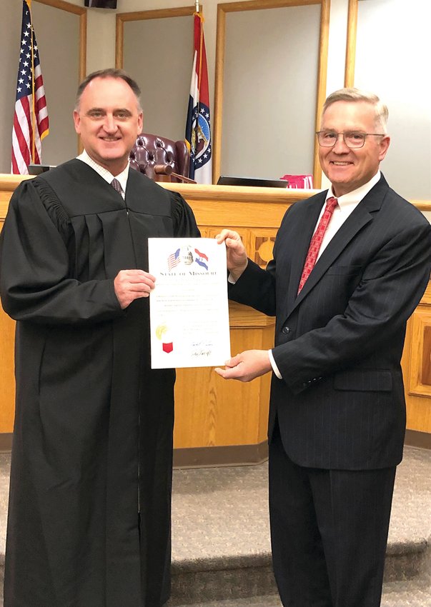 In a brief ceremony conducted by Johnson County Associate Circuit Court Judge Brent Teichman, left, David Pearce, executive director for governmental relations at the University of Central Missouri, recently took the oath of office for his new appointment as a member of the Midwestern Higher Education Compact.