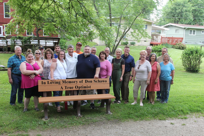Members of the Optimist Club of Warrensburg pose for a picture with a memorial bench dedicated to Don Schawo on Thursday, June 9, in Marr Park.