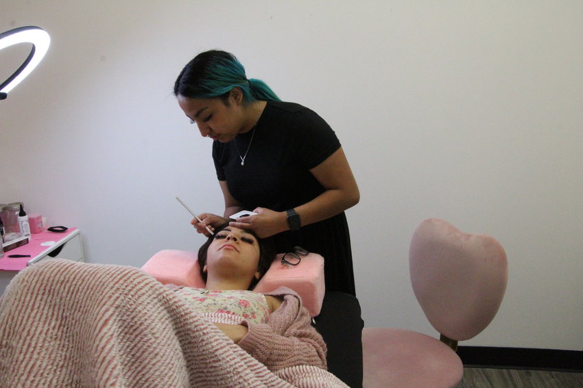 On Thursday morning, Bella by Tere owner Teresa Costilla works on a brow tint for customer Cynthia Fernandez. The brow tint will last Fernandez two weeks before she has to get a fresh tint.