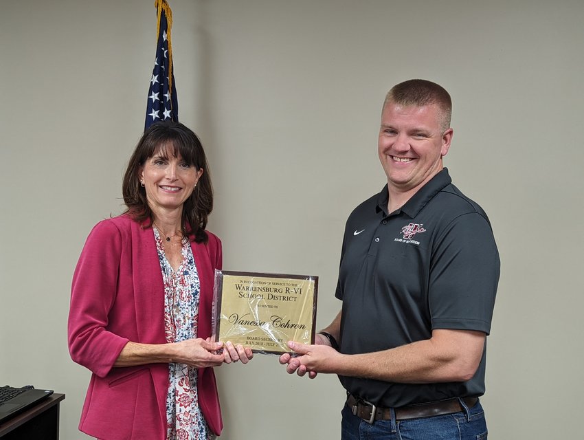 Vanessa Cohron is handed a plaque by Warrensburg School Board of Education President Justin Johnson at the Tuesday, Aug. 16, board meeting recognizing Cohron for her work as the board secretary from July of 2018 to July of 2022.