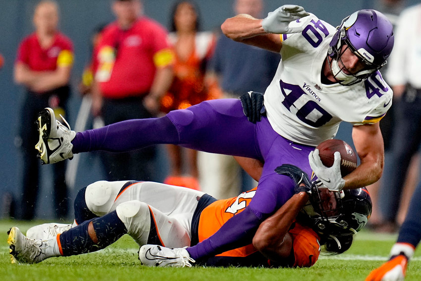 Denver Broncos linebacker Kana'i Mauga tackles Minnesota Vikings tight end Zach Davidson (40) during the first half of an NFL preseason football game, Saturday, Aug. 27, 2022, in Denver.
