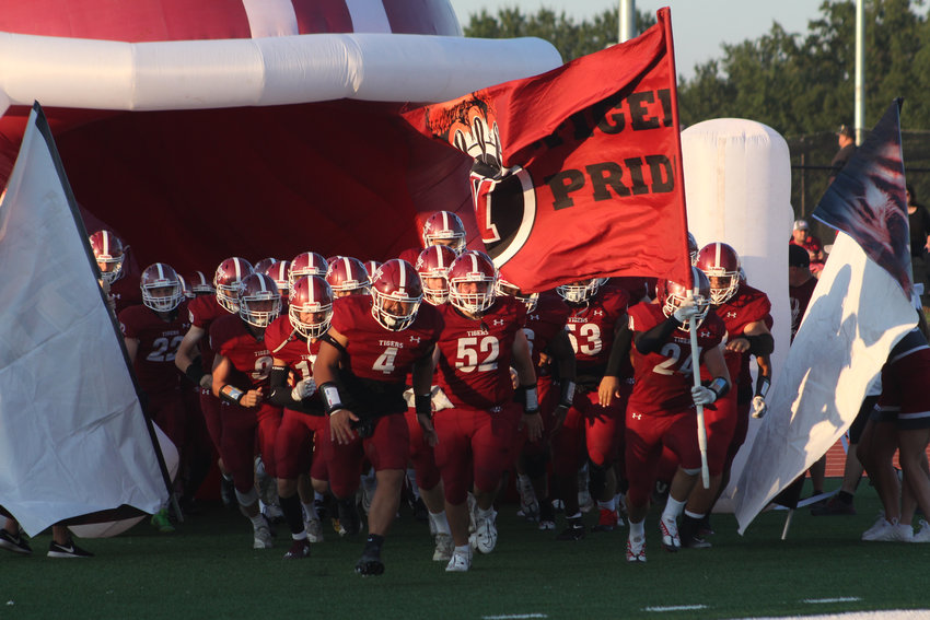 Warrensburg senior Jake Sartwell leads Tigers football out of the tunnel prior to a game against Smith-Cotton on Friday, Sept. 9, at the Warrensburg Activities Complex.