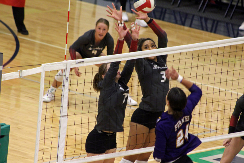 Warrensburg junior Julia Brown and senior Kimberly Maxwell attempt to block an attack from Belton in the Class 4 District 7 semifinals Saturday, Oct. 22, at St. Michael the Archangel.