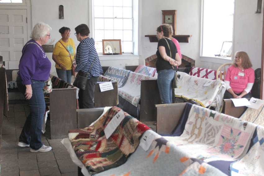 Attendees tour the antique quilts on display Saturday, Oct. 22, in the Old Johnson County Courthouse.
