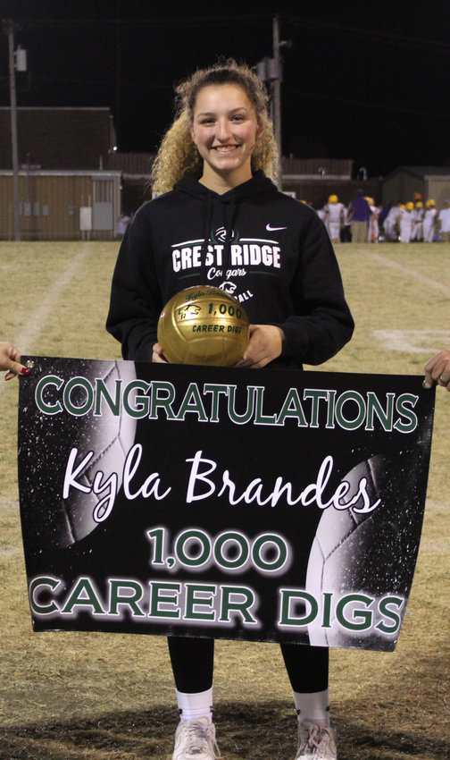 Kyla Brandes holds her golden volley and banner she received for her 1,000 career digs during halftime of the Crest Ridge and Slater football game Friday, Oct. 21.