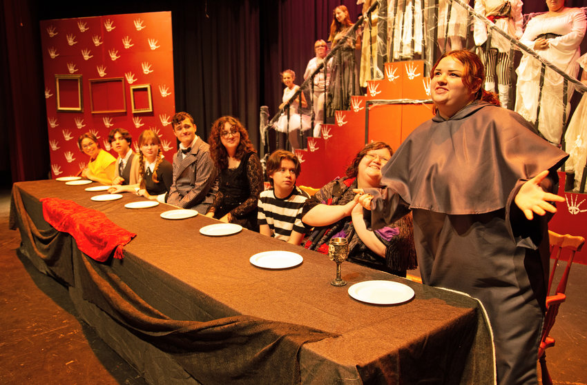 Fester Addams, played by senior Rayleigh Setter, sings about his love while the rest of his family looks on from the table during a rehearsal of &ldquo;The Addams Family&rdquo; on Wednesday night at Warrensburg High School.