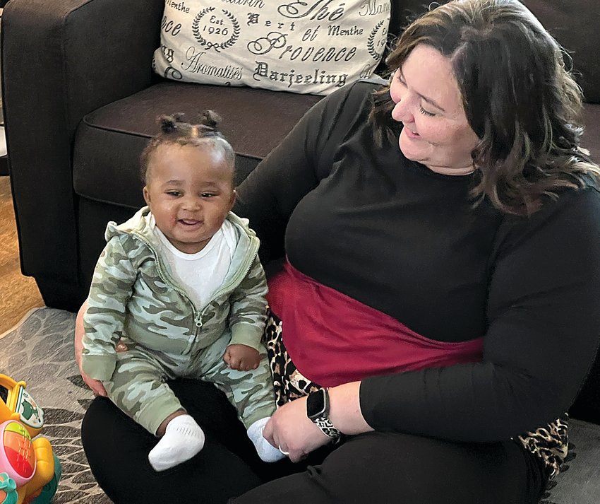 Emily Stocking, the executive director of Zoe's Home in Clinton, holds a resident's son Wednesday morning. Zoe's Home, a faith-based community support for pregnant women and their children, opened Aug. 28.