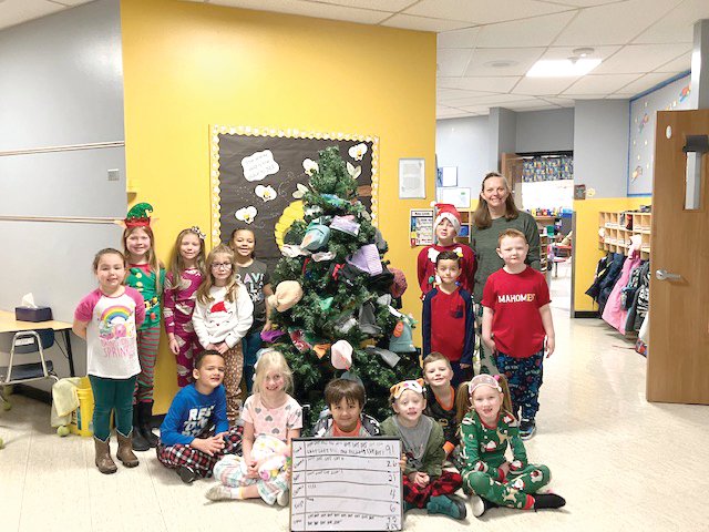Dr. Katie Ritter and her first grade class with their mitten tree covered in donations brought by the students.