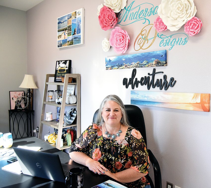 Jamie Anderson, of Ionia and the owner of Anderson Designs Travel LLC, sits at her desk Wednesday afternoon in her home office. Since beginning her business three years ago, she has booked 250 trips and has 500 clients.