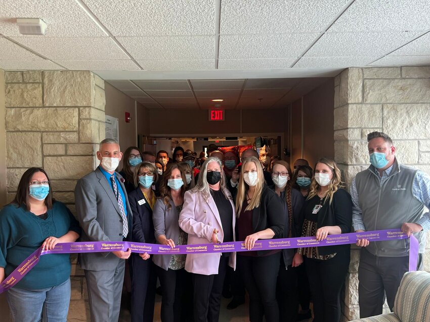Members of the Missouri Veterans Home-Warrensburg and the Warrensburg Chamber of Commerce stand in front of the Special Care Unit at the Veterans Home for a ribbon cutting on Monday, April 10.   Photo by Meliyah Venerable | Star-Journal