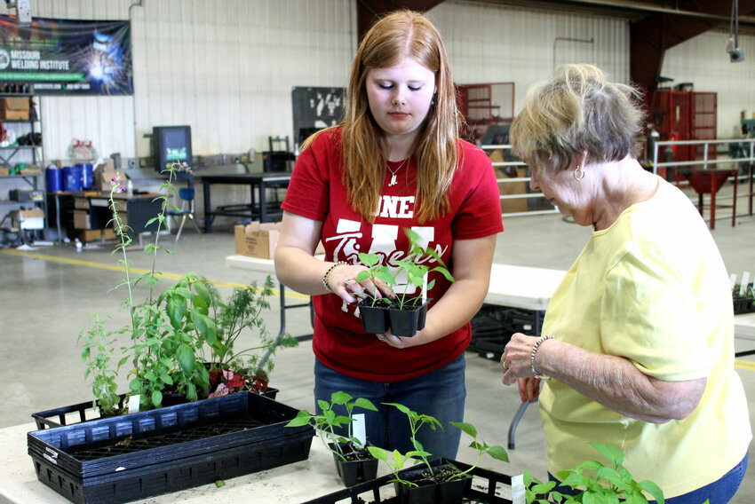 Warrensburg Area Career Center student Madeline Collins, left, helps a customer select some items at the annual spring plant sale Friday morning, April 14. The sale will continue April 17-20.   Photo by Nicole Cooke | Star-Journal