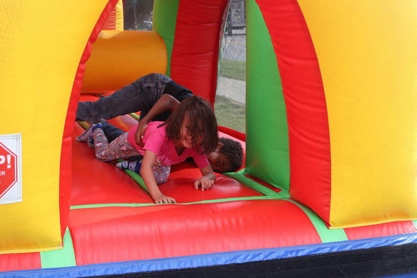 Children laugh as they run through the bounce house course on Wednesday afternoon, May 10 at Family Fun Day for Western Missouri Medical Center.