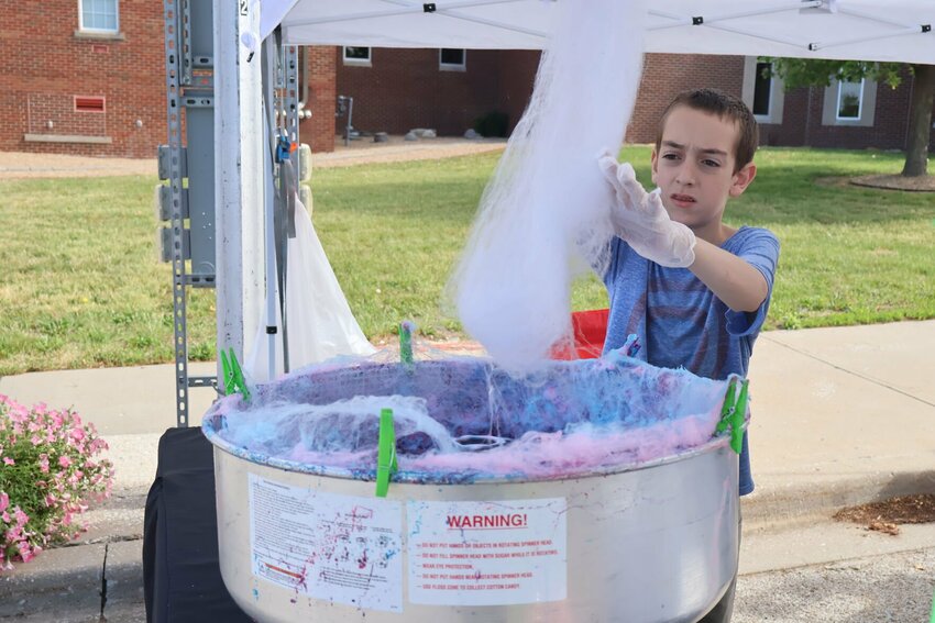 Hayden Morelan of Hayden's Sweets makes cotton candy during the Warrensburg Farmers' Market on Saturday, May 13 in downtown Warrensburg. The farmers market is open from 8 a.m. to noon Saturdays around the Johnson County Courthouse square from May through September.
