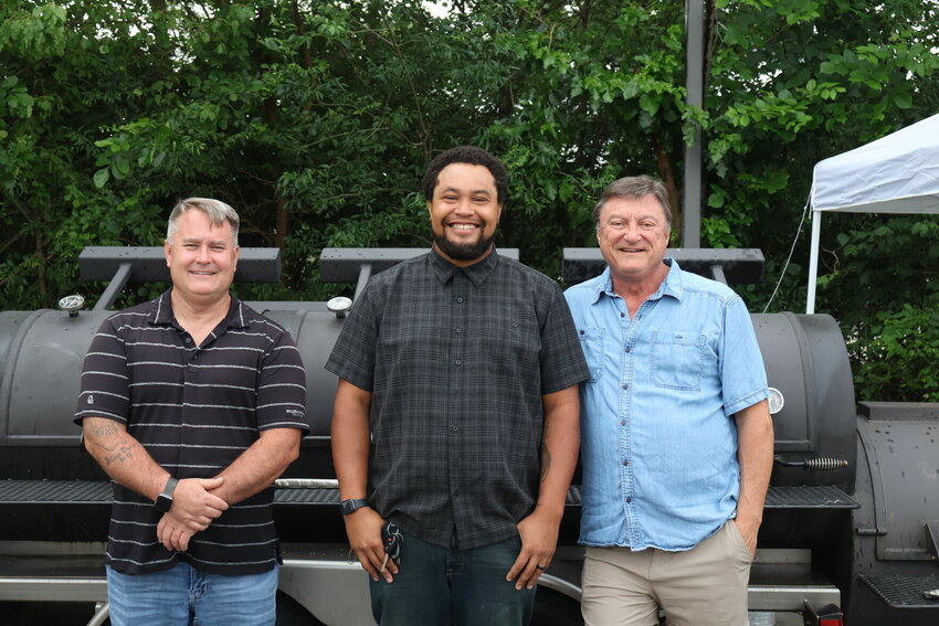 MuleKicker BBQ owners Ben Pierce and Bryan Sams stand in front of the 750-gallon Yoder smoker-trailer with Pit Master and Kitchen Manager Isaiah &quot;Ziggy&quot; Brock, center.&nbsp;
