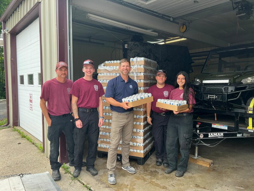 Members of the Johnson County Fire Protection District pose with canned water donated by&nbsp;Anheuser-Busch.&nbsp;