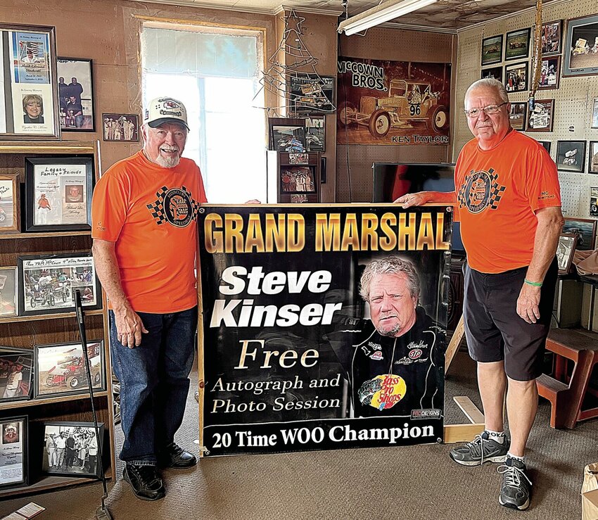Larry McCown, right, the promoter of the Missouri State Fair Championship on the State Fair Speedway, stands with Tom McCown on Wednesday, Aug. 16. The men are standing by a previous poster of racing great Steve Kinser. Kinser's son Craig Kinser will compete in the Championship on Sunday night, Aug. 20 at the Missouri State Fair.   Photo by Faith Bemiss | Sedala=ia Democrat&nbsp;