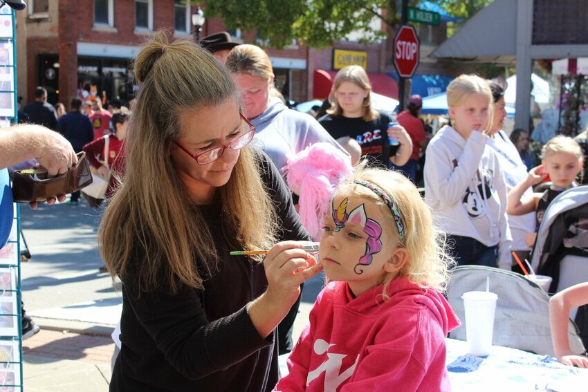 Eleanor Horn gets her face painted at Burg Fest on Saturday, Oct. 8, 2022, in downtown Warrensburg. Warrensburg Main Street will host the 10th annual street fair on Oct. 6-7.