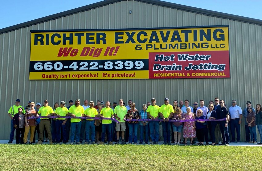 Owners Lorenz and Lisa Richter, center, cut the ribbon for their new Richter Excavating and Plumbing facility on Monday, Oct. 2 during a Warrensburg Chamber of Commerce ribbon cutting ceremony.